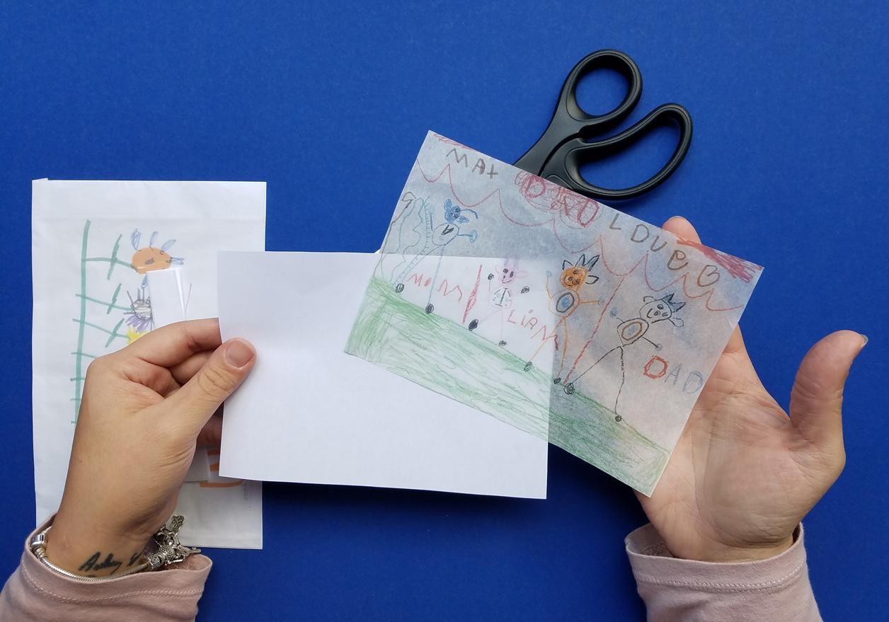 You won’t even have to untape the tissue paper. Cut around the edges of your photo and it will slide off easily.